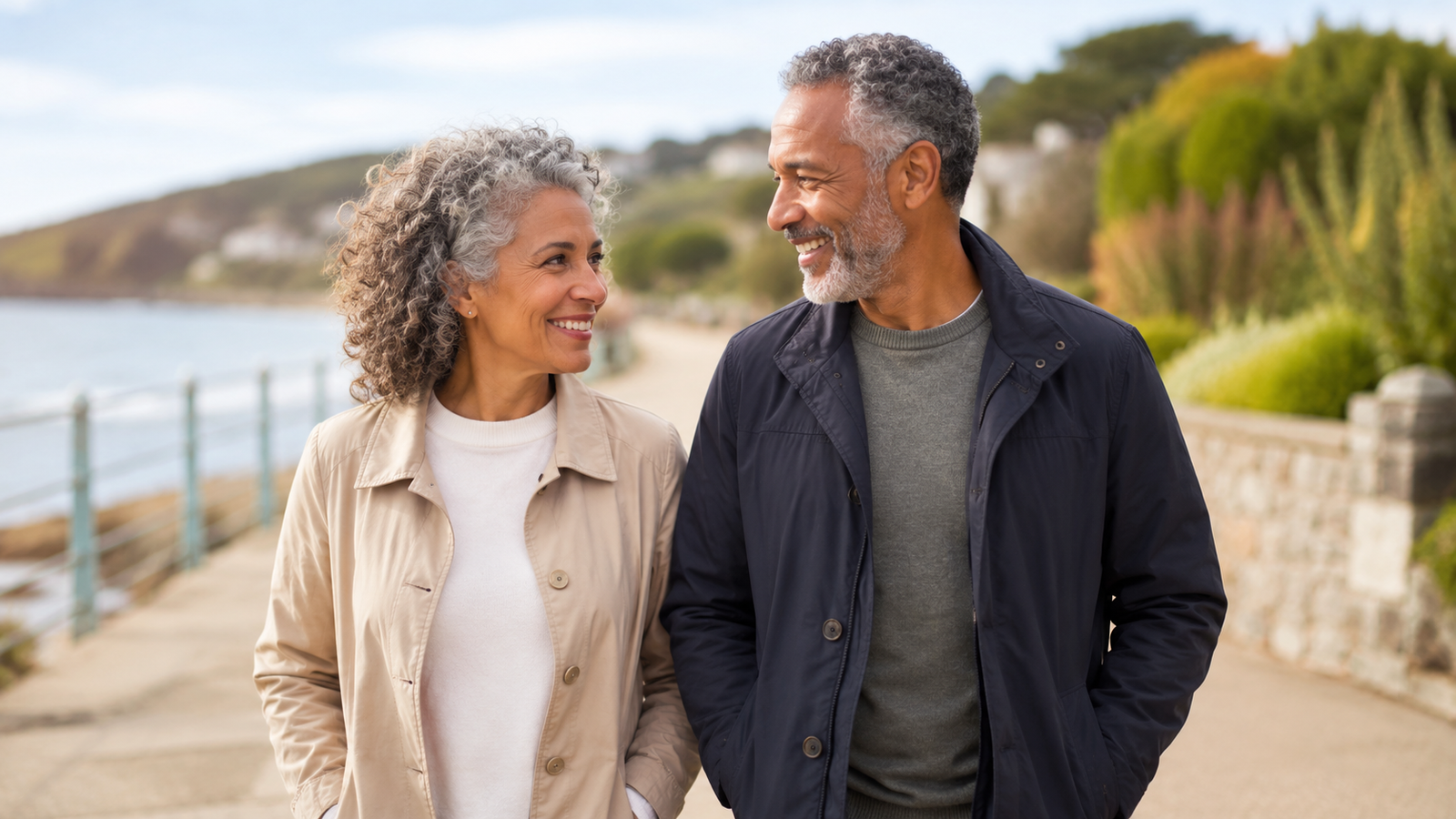 Couple over 50 enjoying a relaxed walk together along a coastal path.