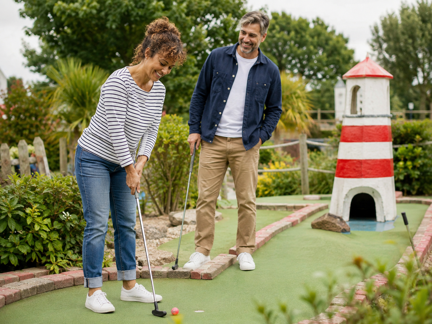 Couple enjoying a playful affordable mini golf date